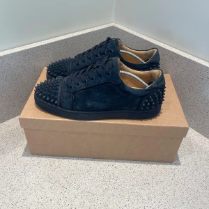 Mörkblå Christian Louboutin sneakers - Säljer ett par mörkblå sneakers från Christian Louboutin i mocka. Dustbags extra skosnören och box medföljer vid köp