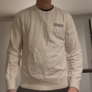 Vit sweatshirt från Wood Wood - Säljer en stilren beige sweatshirt från Wood Wood i storlek medium. Tröjan har rund halsringning, diskret svart tryck på bröstet och är tillverkad i mjuk bomull. Perfekt för en clean och avslappnad look. Nypris cirka 1500!