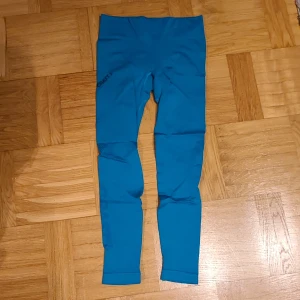 Blå träningstights från Craft XS/S - Säljer ett par blå träningstights från Craft i storlek XS/S. De är högmidjade och har en tight passform, perfekta för gymmet eller löpning. Materialet är stretchigt och andas, vilket gör dem riktigt sköna att röra sig i.