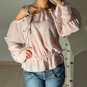 Rosa blus med volanger  - Storlek 12, uppskattas passa s-m