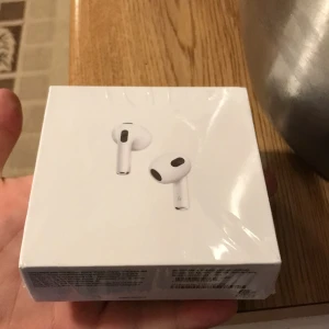 Apple AirPods (MagSafe Charging Case) - Helt nya Apple AirPods med MagSafe-laddningsetui, fabriksförseglad i originalförpackning. Trådlösa hörlurar med smidig laddning och hög ljudkvalitet. Perfekt för musik, samtal och vardagsanvändning. Ingen synlig skada eller slitage.
