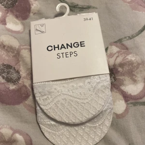 Vita låga strumpor från Change Steps - Säljer ett par vita låga strumpor från Change Steps i storlek 39-41. De har ett diskret mönster och är tillverkade av 60% bomull, 35% polyamid och 5% elastan. Perfekta för sneakers eller låga skor när du vill ha en clean look.