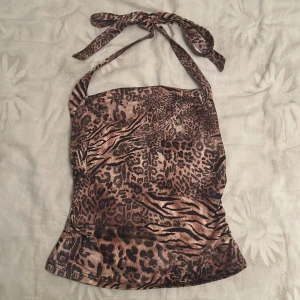 Leopardmönstrad halterneck topp - Snygg halterneck topp från SHEIN med leopardmönster i bruna och svarta toner. Toppen knyts i nacken, jättemysigt material❤️använd max 2 gånger, säljer eftersom att jag inte använder den så mycket