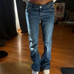  blå jeans bootcut - Säljer ett par klassiska jeans i blå tvätt med bootcut-snitt. Jeansen har fem fickor, knappgylf och normal passform. Materialet är slitstarkt jeans i bomull. Perfekt för dig som gillar tidlös stil och vill ha ett par snygga jeans med lite vidare ben.