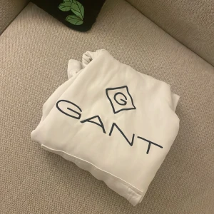 Gant hoodie - Säljer en fin gant hoodie i storlek 146/152 (11-12) Har några enstaka små fläckar (se bild) som jag sett. (Kan kolla en gång till om ni vill) Jag lägger knappt märke till dom:) men övrigt fin klassisk tröja som går att styla enkelt. Hör gärna av er om funderingar:) nypris ca 700