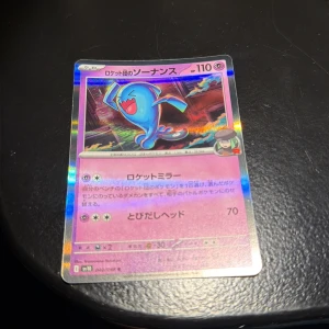 ロケット団のソーナンス (Team Rocket's Wobbuffet) - Cool och glittrande japansk Pokémon-samlarbild med Wobbuffet från Team Rocket! Perfekt för dig som älskar Pokémon och vill ha något unikt i din samling. Kortet har färgstark design och är ett måste för fans av trading cards och anime.