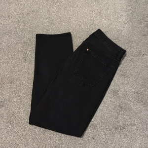 Svarta relaxed jeans från H&M - Svarta jeans från H&M i relaxed fit med klassisk femficksdesign och bälteshällor. Jeansen har raka ben och är tillverkade i ett slitstarkt bomullstyg. Perfekta för en chill och avslappnad stil.