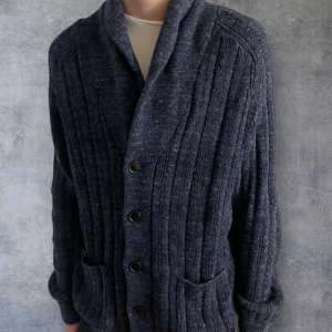 Mörkblå stickad kofta från Pier One - Säljer en mörkblå stickad kofta från Pier One med ribbad struktur och snygga knappar framtill. Koftan har två praktiska fickor och långärmad design, perfekt för att hålla värmen. Stilren och klassisk look som funkar till många outfits.