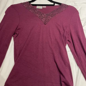 Vinröd långärmad topp med spets - Supersnygg vinröd långärmad topp från Gina Tricot med v-ringad hals och dekorativ spetsdetalj. Använt 2 gånger och är som ny