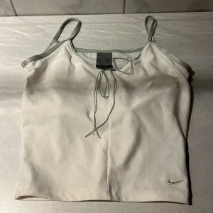 Vit topp från Nike med silverdetaljer - Supersnygg vit topp från Nike. Dri-Fit material. 