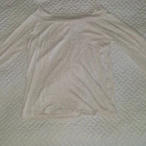 Offshoulder topp från ONLY - Säljer en stilren beige offshoulder topp från ONLY i storlek S. Toppen har lång ärm och är gjord i mjukt, tunt material som känns skönt mot huden. Perfekt för dig som gillar enkel och clean look.