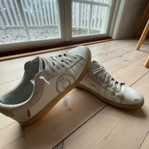 Vita sneakers från Oliver Cabell  - Snygga vita sneakers från Oliver Cabell, i limited edition 2024. Har använts under våren och sommaren men är fortfarande i gott skick! Perfekt för en stilren look för dig som vill se fräsch ut.