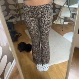 Leopardmönstrade bootcut byxor - Säljer ett par snygga leopardmönstrade byxor med bootcut-snitt. Byxorna har hög midja och är i ett stretchigt, man kan vika ner kanten som  yoga pants. mjukt material som sitter skönt på kroppen. Perfekta för dig som vill sticka ut med ett trendigt djurmönster.