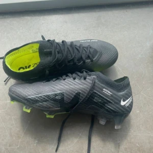 Nike Fotbollskor  - Nike Air Zoom Mercurial Vapor 15 Elite FG. Köpta på unisport, använda endast två gånger så i väldigt bra skick. I storlek 36,5. Nypris: 3149kr. Unisex