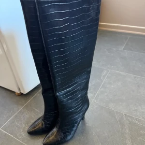 Boots - Säljer ett par svarta höga stövlar med krokopräglat mönster.  Super snygga och varma på. Har använt 2 gånger en kort stund som nya typ. Säljer då det inte riktigt var min grej med skorna.