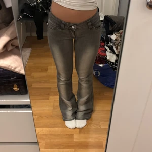 Grå bootcut jeans låg midja - Ett par grå jeans med bootcut och låg midja. Ganska stretchiga från weekday. Osäker på storlek men skulle gissa på 27/32. Passar mig som är 165 cm lång och vanligtvis bär 34/xs