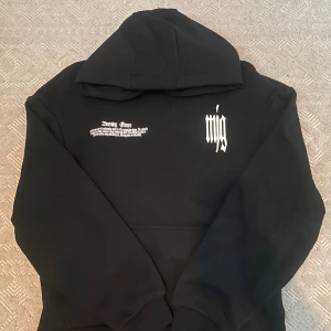 NY Svart hoodie MJGONZALES - Svart hoodie MJGONZALES med vit text på bröstet och stor röd butterfly-print på ryggen. Hoodien har huva, ribbade muddar och tryck i gotisk stil både fram och bak. Perfekt för dig som gillar streetwear med edgy vibe.