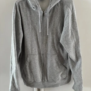 Zip hoodie - Säljer en grå baggie zip hoodie  Har två fläckar på luvan men i övrigt i mycket bra skick  Stl L 