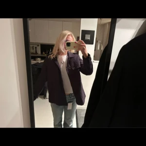 Mörkblå parkajacka med knappar - Snygg mörkblå parkajacka med klassisk krage och knappar framtill. Jackan har axelklaffar, fickor med lock och en slits bak för extra rörelsefrihet. Tillverkad i ett mjukt bomullsmaterial, perfekt för dig som gillar stilren och enkel design.