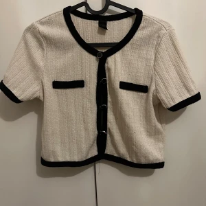 Beige kortärmad blus med svarta detaljer - Står M men är som XS så skriver den som Xs