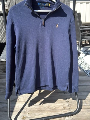  Polo Ralph Lauren zip - Klassisk marinblå långärmad tröja från Polo Ralph Lauren med halv dragkedja och broderad logga på bröstet. Tröjan har hög krage och är tillverkad i mjukt bomullsmaterial. Perfekt för en avslappnad men stilren look.
