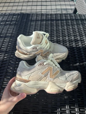 Beige New Balance sneakers - Snygga sneakers från New Balance i beige mesh och mocka med detaljer i guld och vitt. Skorna har chunky sula och klassisk N-logga på sidan. Perfekta för dig som gillar streetwear och vill ha en unik touch på outfiten. De är nya, oanvända men har ingen kartong kvar. 