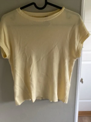 Ljusgul t-shirt från MNG - En enkel och stilren ljusgul t-shirt från MNG. T-shirten har rund halsringning och korta ärmar. Tillverkad i mjuk bomull som känns skön mot huden. Perfekt till jeans eller kjol för en avslappnad look.