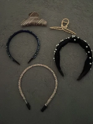 Mix av diadem med pärlor och glitter - Säljer tre snygga diadem: ett svart med pärlor, ett glittrigt i guld och ett mörkblått med små pärlor. Perfekta accessoarer för att lyfta din look. En hårklämma och en hårsnodd i guld ingår också.