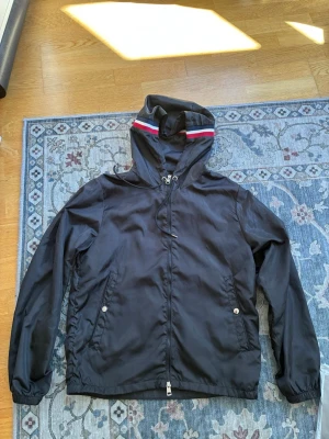 Moncler windbreaker - Säljer denna Moncler windbreakern då den inte längre används. Jackan är i bra skick utan skador eller slitage. Passar perfekt för både varmt väder och när det är lite kyligare, hör av er vid frågor!