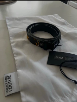 Svart skärp från Versace Jeans Couture - Versace Jeans Couture bälte Ny pris ca 1700 om jag minns rätt 90 cm Bra skick finns en jätte liten defekt men inget som påverkar. Skriv vid frågor  ALLT PÅ BILDEN MEDFÖLJER