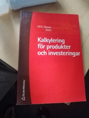 Kalkylering för produkter och investeringar - Kursbok med titeln 'Kalkylering för produkter och investeringar' av Ulf E. Olsson (red.). Boken har ett rött och brunt omslag med vit text och ges ut av Studentlitteratur. Perfekt för dig som pluggar ekonomi eller management.
