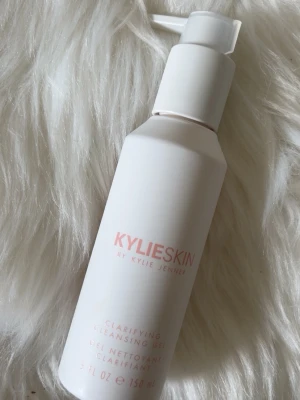 Kylie Skin Clarifying Cleansing Gel - Fräsch rengöringsgel från Kylie Skin i en stilren vit pumpflaska. Produkten är på 150 ml och har en mjuk rosa text på framsidan. Perfekt för dig som vill ha en effektiv men skonsam ansiktsrengöring i din hudvårdsrutin.