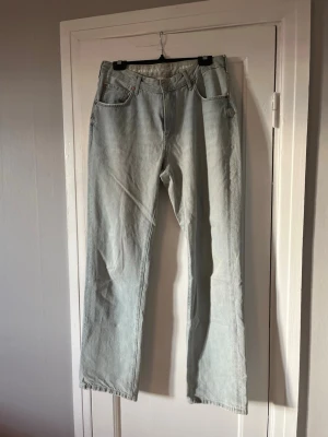 Ljusblå raka jeans med hög midja - Säljer ett par ljusblå jeans med rak passform och hög midja. Klassisk femficksmodell med bälteshällor och dragkedjegylf. Perfekta till en avslappnad stil och passar till det mesta i garderoben.