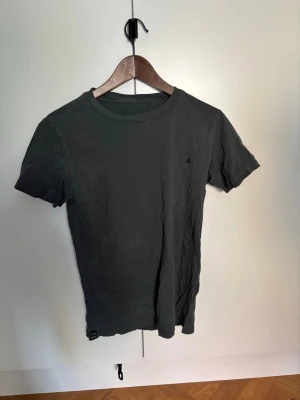Mörkgrå t-shirt från Replay - Snygg mörkgrå t-shirt från Replay med diskret logga på bröstet och rund halsringning. Tillverkad i mjuk bomull som känns skön mot huden. Perfekt basplagg till garderoben och passar till det mesta.