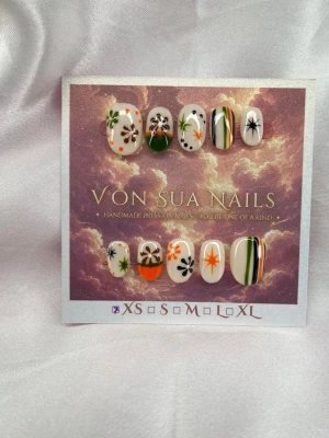 Groovy (XS);;ExtraShortOval  - Snygga press-on naglar i en unik designe med handmålade blommor och stjärnor i orange, svart, vitt och grönt. Mixade mönster med både ränder och prickar på en ljusbeige bas. Perfekt för dig som vill ha unika och kreativa naglar. XS: 14 mm, 11 mm, 11,5 mm, 10 mm, 8 mm