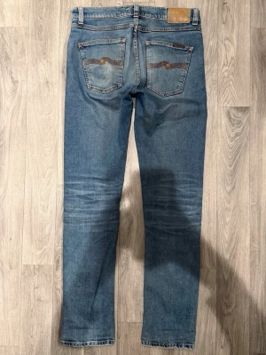 Nudie Jeans Lean Dean Ljusblå W29/L32 - Slim Tapered Fit - Nudie Jeans Lean Dean ”Lost Orange” ljusblå jeans med slim tapered-passform, normalhög midja och avsmalnande ben, storlek W29/L32, midja 40,5 cm, ytterbenslängd 106 cm, benöppning 16 cm, modellen är 185cm & väger 65kg, i fint skick.