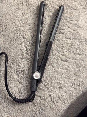 Svart plattång från Amika - Säljer en svart plattång från Amika, modell No 534. Plattången har digital display, temperaturreglage och sladd med vridbart fäste. Perfekt för att styla håret snabbt och enkelt. Materialet är plast och metall.