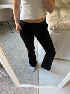 Svarta lågmidjade kostymbyxor - Säljer ett par svarta kostymbyxor från Bik Bok i storlek 34, modell Petite🖤. Byxorna har låg midja, hyfsat raka ben och fickor både fram och bak. De har knapp- och dragkedjestängning och är perfekta att matcha med både topp och skjorta för en stilren look!✨