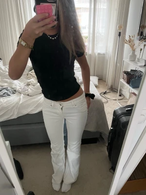 Vita bootcut jeans med låg midja - Säljer ett par supersnygga vita bootcut jeans med låg midja från hm. jag är 160cm och dom är uppsydda lite i längden men i jättebra kvalité🥰storlek: 32 och i bra skick 