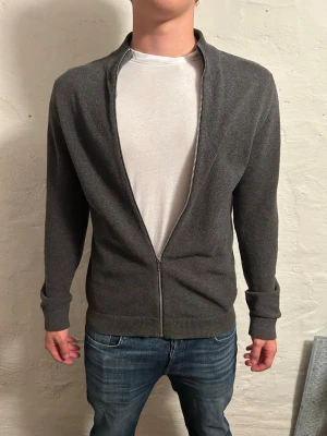  ziptröja  - Snygg mörkgrå ziptröja i storlek M. Modell är 185cm. Hör av er vid funderingar!