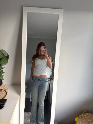 Ljusblå bootcut jeans - Säljer ett par ljusblå bootcut True religion  jeans med klassisk femficksdesign och låg midja. Jeansen har en ljusblå  look och är tillverkade i denim med lite stretch för skön passform. Perfekta för dig som gillar en avslappnad och trendig stil.