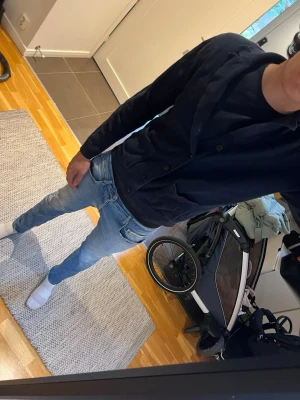 Mörkblå ribbad kofta med knappar - Snygg mörkblå kofta med ribbad struktur och knäppning framtill. Koftan har två fickor och en bred krage som ger en avslappnad men stilren look. Perfekt att slänga på sig över en t-shirt för en enkel men trendig outfit.