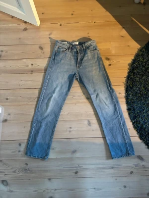 Blå relaxed jeans från Jack & Jones - Säljer ett par ljusblå relaxed fit jeans från Jack & Jones, modell Chris. Klassisk femficksdesign, raka ben och normal midja. Perfekta för en chill och avslappnad stil. Tillverkade i slitstark denim med snygg tvättad look.