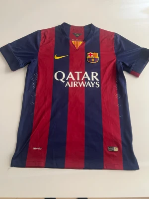 Barcelona 14/15 Neymar  - Säljer en FC Barcelona matchtröja från Nike med Neymar Jr och nummer 11 på ryggen. Tröjan har blå och vinröda vertikala ränder, Qatar Airways-tryck på bröstet och klubbmärke. Tillverkad i lätt funktionsmaterial, perfekt för fotboll eller samling.