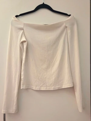 Offshoulder vit långärmad topp - Offshoulder topp i vitt med långa ärmar. Har några fläckar på ena ärmen som möjligtvis går bort i tvätt (har inte testat)