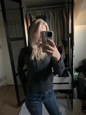 Mörkgrå hoodie med dragkedja - Mysig mörkgrå hoodie med dragkedja framtill och huva. Tillverkad i ett mjukt, stickat material som ger en avslappnad och skön känsla. Passar perfekt till jeans och har en enkel, stilren design utan synligt märke. Beställd från Nelly men i märket JJXX. Använd 1 gång