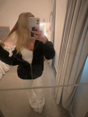Svart hoodie med dragkedja och huva - Säljer en svart hoodie med dragkedja och huva. Hoodien har en avslappnad passform och är perfekt att slänga på sig över en t-shirt eller linne. Klassisk look med långa ärmar och fickor framtill.