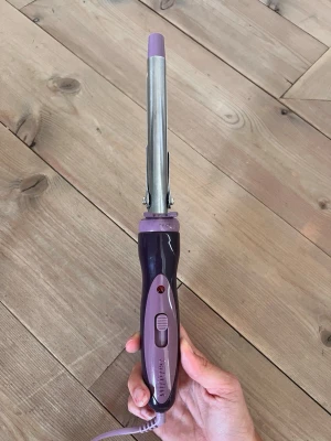 Lila locktång med smalt skaft - Baby Liss locktång i lila och silver med smalt metallskaft och plastdetaljer. Perfekt för att skapa lockar eller vågor i håret. 