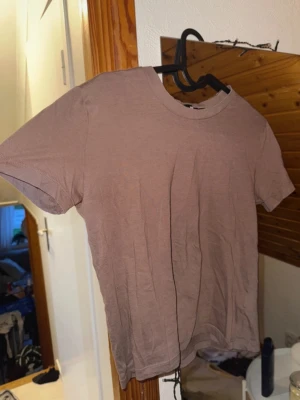 Brun basic t-shirt från BikBok - En enkel brun t-shirt från BikBok i storlek XS. T-shirten har rund halsringning och korta ärmar, perfekt till alla outfits. Tillverkad i mjuk bomull