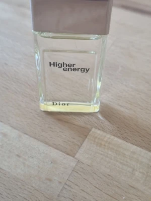 Dior Higher Energy Eau de Toilette - Dior Higher Energy Eau de Toilette med fräsch och energisk doft. Flaskan är rektangulär i genomskinligt glas med silverfärgat lock och ljusgul vätska. Modern och stilren design som passar perfekt i badrumshyllan.